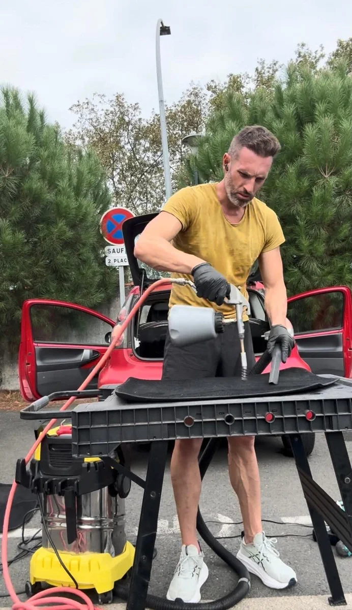 Cédric nettoie un tapis automobile avec son matériel professionnel